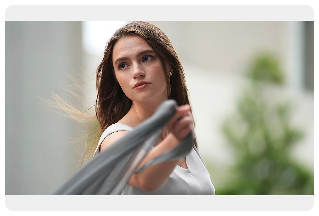 Sony A7 IV Sample image portrait of wearing white dress holding grey fabric blowing in the wind